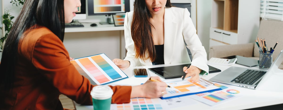 Two designers pairing colors and layouts for a client website